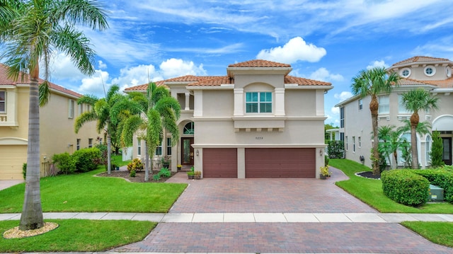 9229 Delemar Ct, Wellington, FL 33414 - mediterranean / spanish home featuring a tiled roof, an attached garage, stucco siding, a front yard, and decorative driveway