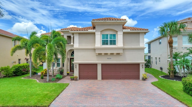 9229 Delemar Ct, Wellington, FL 33414 - mediterranean / spanish-style home with a tiled roof, stucco siding, a garage, a front yard, and decorative driveway