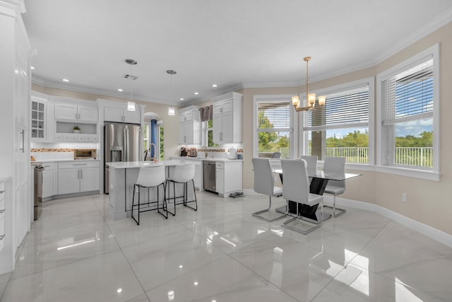 kitchen featuring white cabinets, a center island, a healthy amount of sunlight, and light tile patterned floors