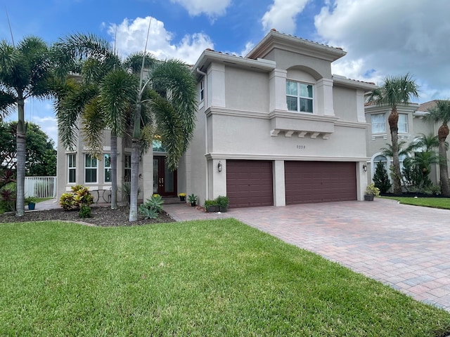 mediterranean / spanish home featuring a garage and a front lawn