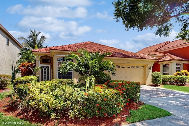 mediterranean / spanish home with concrete driveway, an attached garage, a tile roof, and stucco siding