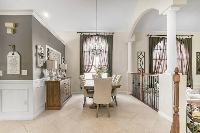 dining space featuring light tile patterned floors, decorative columns, an inviting chandelier, and ornamental molding