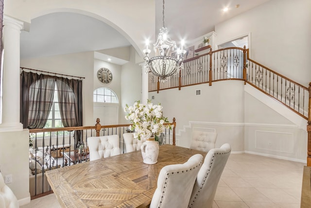 dining room with an inviting chandelier, decorative columns, and light tile patterned floors