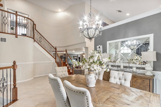 tiled dining room with a towering ceiling, crown molding, and a chandelier