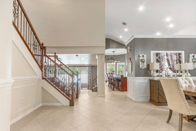 interior space featuring vaulted ceiling, light tile patterned flooring, crown molding, and a chandelier