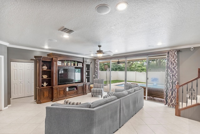 tiled living room with ceiling fan, ornamental molding, and a textured ceiling