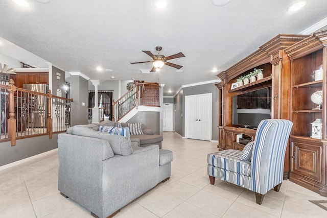 living room with ceiling fan, ornamental molding, and light tile patterned floors