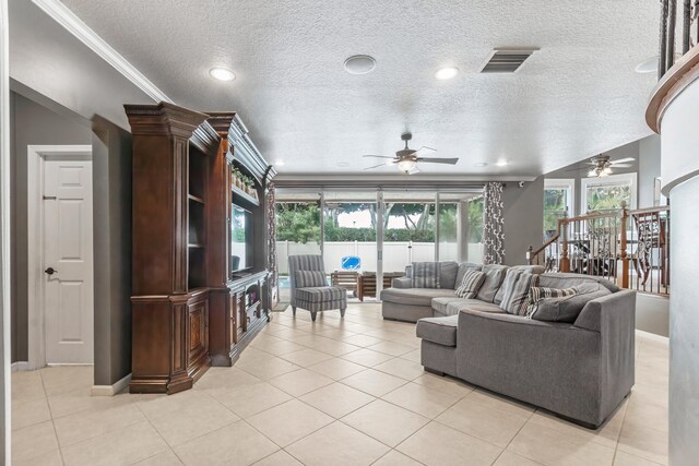 tiled living room featuring ceiling fan, a textured ceiling, and ornamental molding