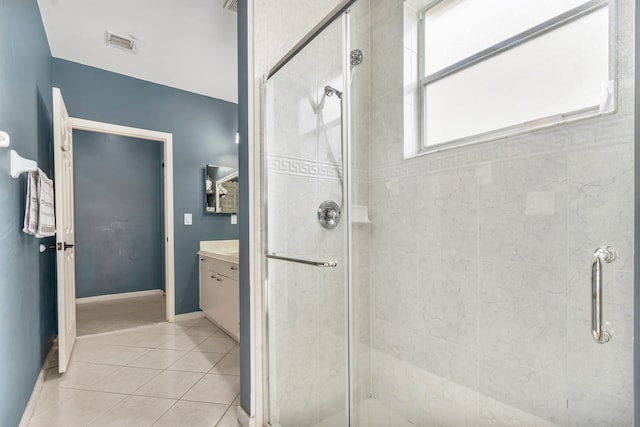 bathroom featuring tile patterned flooring, vanity, and walk in shower