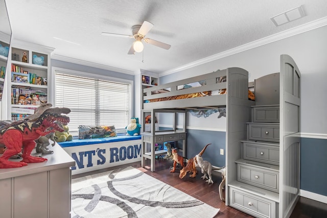 bedroom with ceiling fan, dark wood-type flooring, ornamental molding, and a textured ceiling