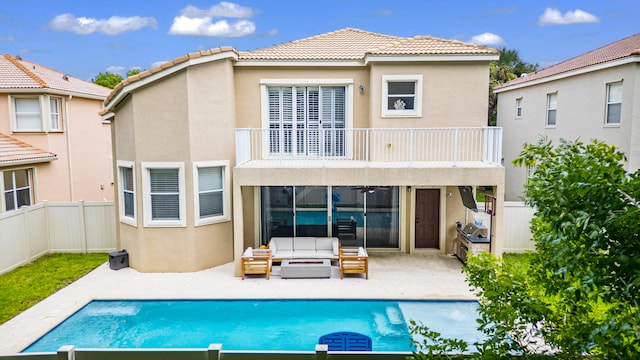 rear view of property featuring a patio and a balcony