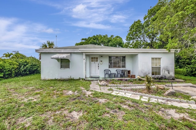 ranch-style house with covered porch and a front yard