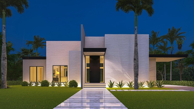 contemporary home with stucco siding and a yard