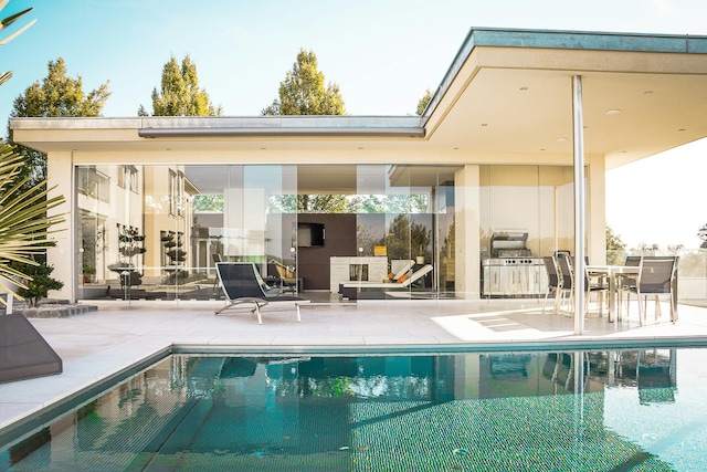 view of swimming pool with a patio and an outdoor fireplace