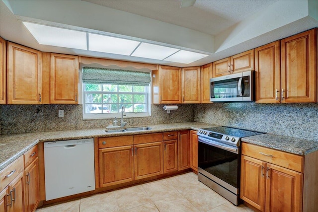 kitchen featuring stainless steel appliances, sink, and backsplash