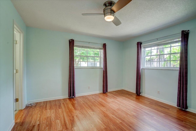 empty room with ceiling fan, light hardwood / wood-style floors, and a textured ceiling