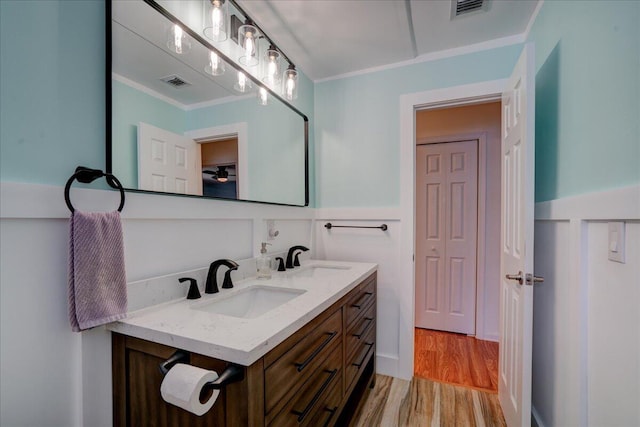 bathroom with vanity, wood-type flooring, and ornamental molding