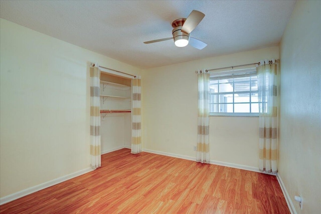 unfurnished bedroom featuring a closet, ceiling fan, a textured ceiling, and light hardwood / wood-style flooring