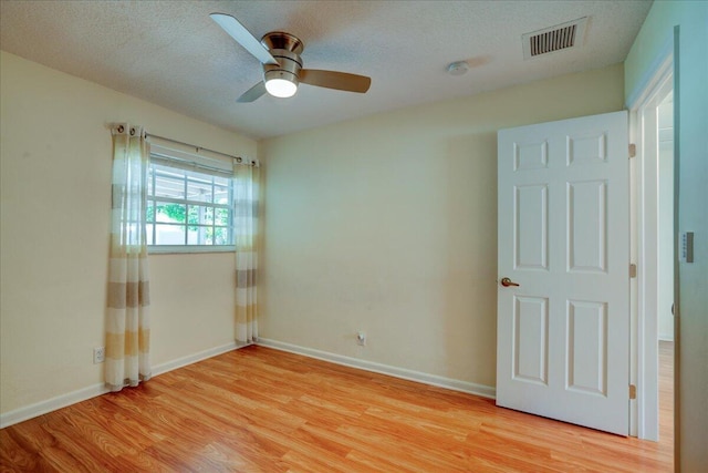 unfurnished room featuring ceiling fan, a textured ceiling, and light hardwood / wood-style floors