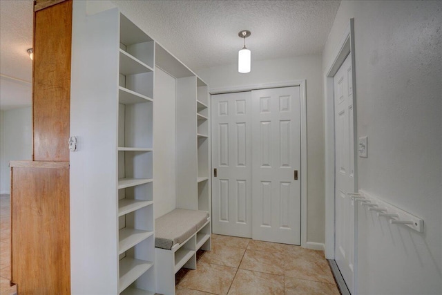 mudroom featuring light tile patterned floors and a textured ceiling