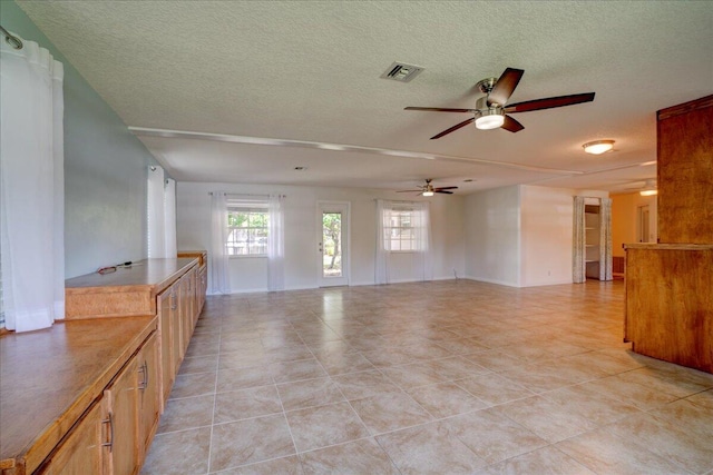 unfurnished living room with light tile patterned floors and a textured ceiling