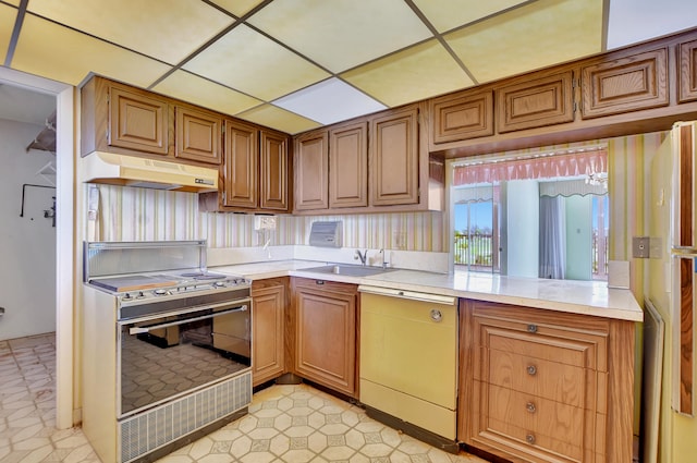 kitchen featuring sink, white appliances, light tile patterned flooring, and kitchen peninsula