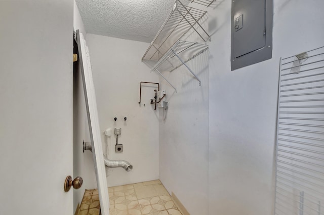 washroom featuring light tile patterned flooring, hookup for an electric dryer, a textured ceiling, and electric panel