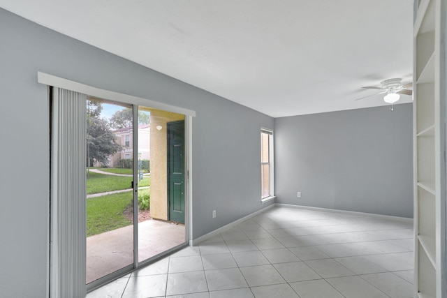 spare room with ceiling fan, light tile patterned floors, and a healthy amount of sunlight