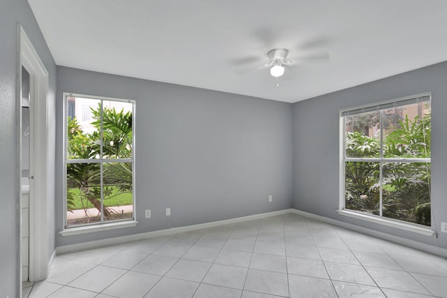 unfurnished room with ceiling fan and light tile patterned floors