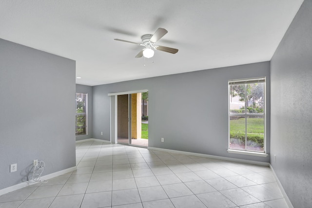 tiled spare room with ceiling fan