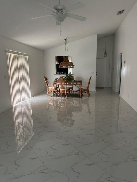 dining area featuring ceiling fan and vaulted ceiling