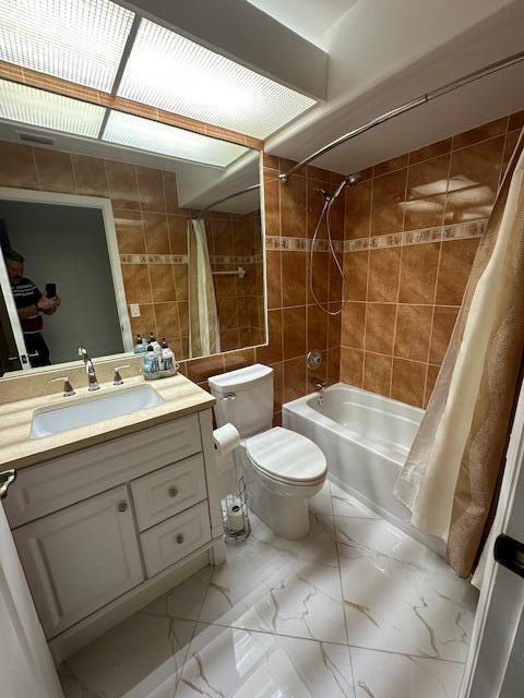 full bathroom featuring vanity, toilet, and shower / bath combo with shower curtain