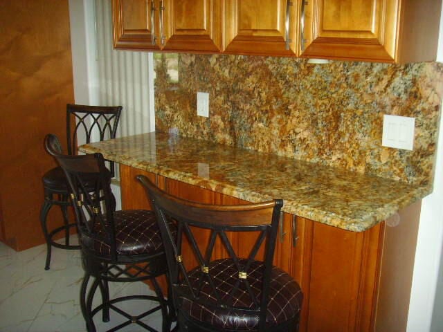 bar with decorative backsplash and light stone counters