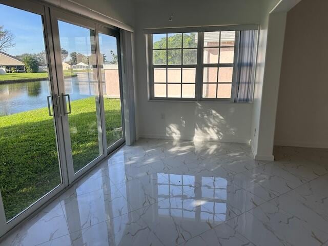 unfurnished sunroom featuring a water view and a healthy amount of sunlight