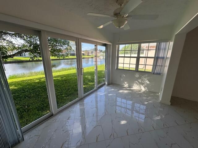 unfurnished sunroom with ceiling fan and a water view