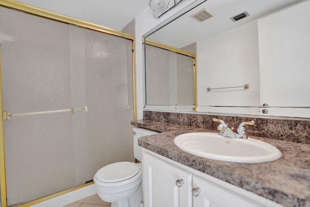 bathroom with tile patterned floors, vanity, a shower with door, and toilet