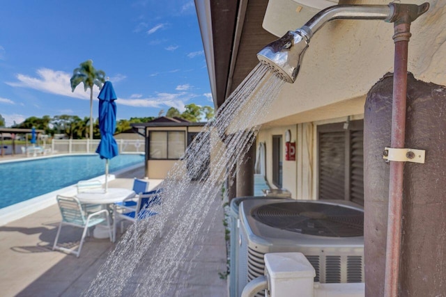 view of patio / terrace with central AC unit and a community pool