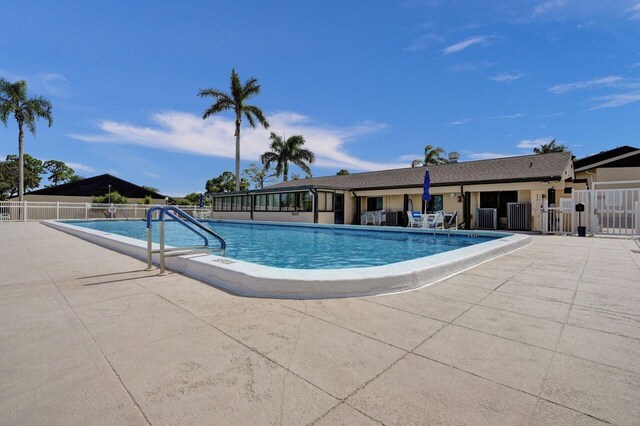 pool featuring a patio area, fence, and central AC