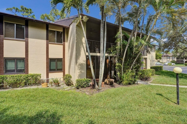 442 Pine Glen Ln Unit B2, Greenacres, FL 33463 - view of property exterior featuring a yard, metal roof, and stucco siding