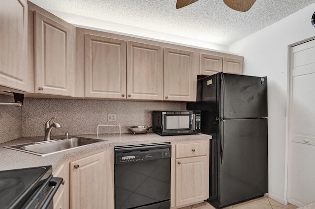 kitchen featuring light countertops, light brown cabinets, a sink, and black appliances