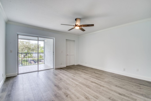 spare room with a ceiling fan, wood finished floors, crown molding, and baseboards