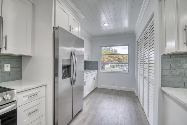 kitchen featuring decorative backsplash, white cabinets, ornamental molding, light hardwood / wood-style floors, and stainless steel fridge