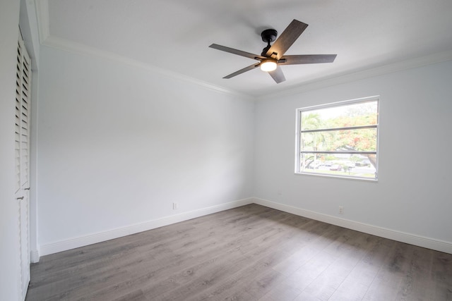 unfurnished room with wood finished floors, ornamental molding, ceiling fan, and baseboards