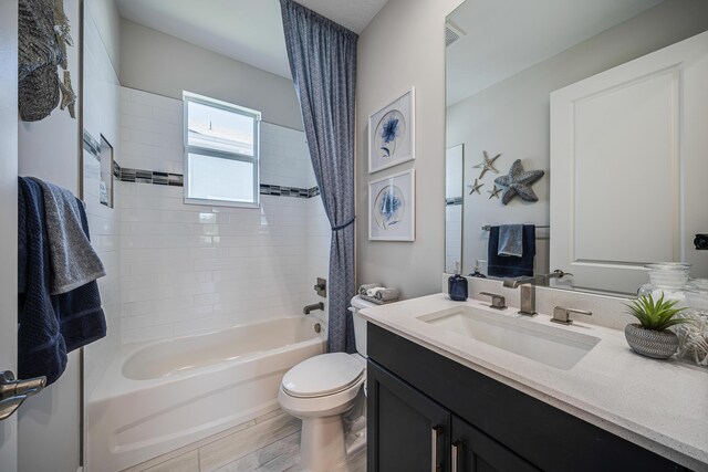 full bathroom featuring vanity, shower / bath combo, and toilet