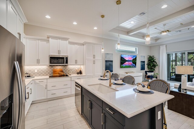 kitchen featuring pendant lighting, white cabinets, beam ceiling, appliances with stainless steel finishes, and sink