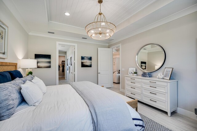 bedroom featuring a raised ceiling, light hardwood / wood-style floors, a chandelier, and ornamental molding