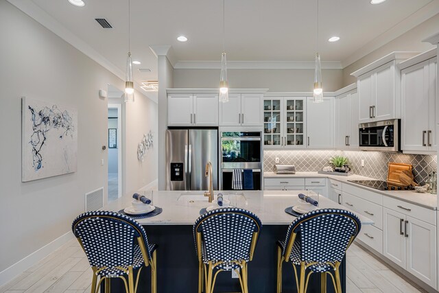 kitchen with crown molding, stainless steel appliances, light stone countertops, and hanging light fixtures