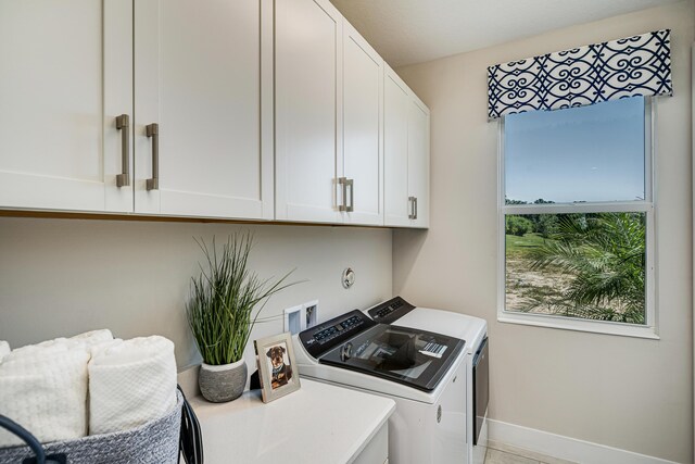 laundry room featuring washer and dryer and cabinets