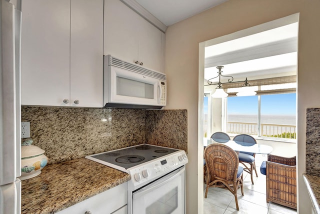 kitchen with stone counters, white cabinetry, white appliances, backsplash, and light tile patterned flooring