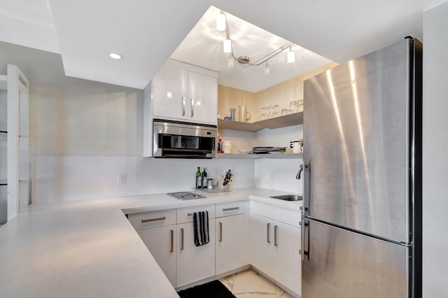 kitchen with stainless steel appliances, sink, decorative backsplash, and white cabinetry